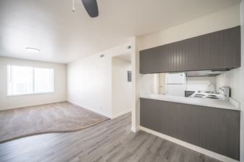 an empty living room and kitchen with white walls and wood flooring  at Summit, Pocatello